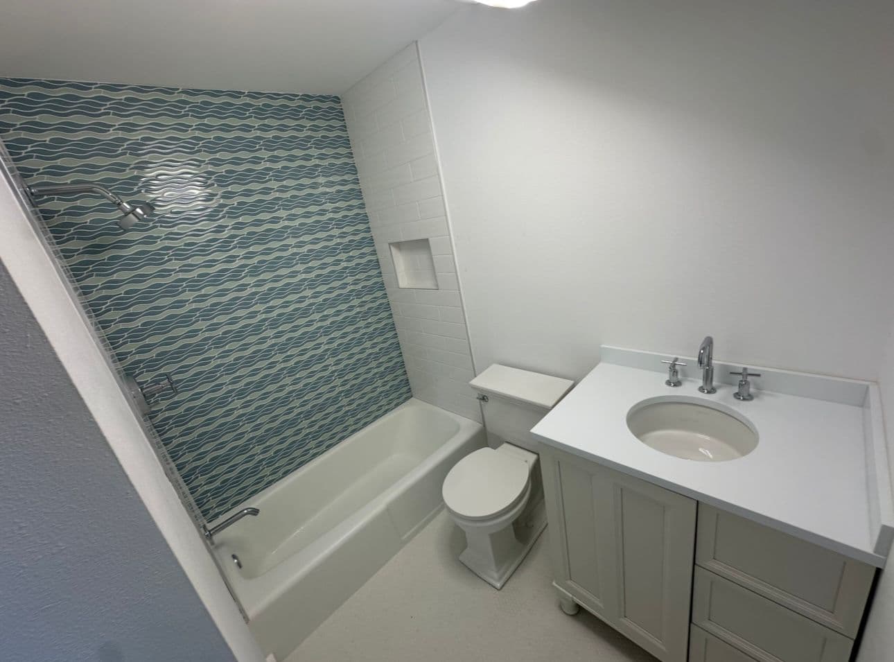 Bathroom remodel with blue wave tile shower and white vanity in North Port FL