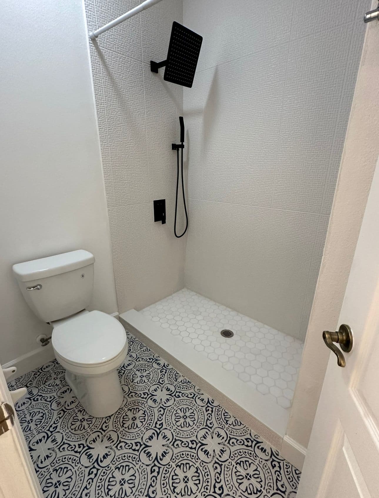 Bathroom remodel with white tile shower and blue patterned floor in North Port FL