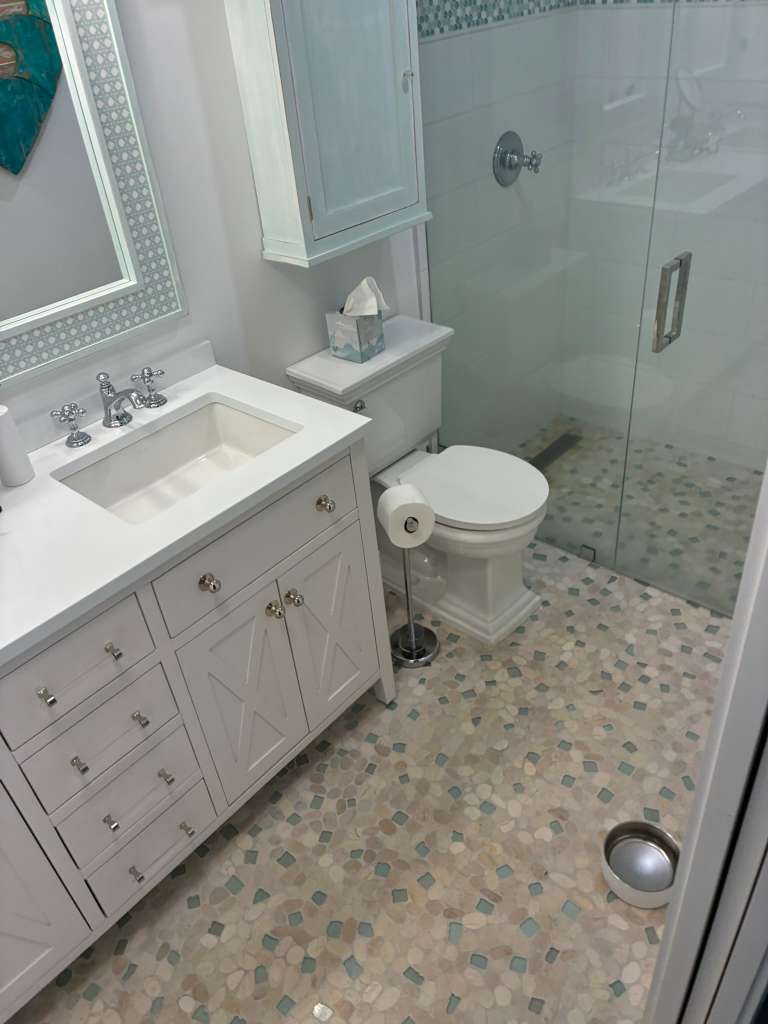 Bathroom remodel with white vanity glass shower and pebble tile in North Port FL