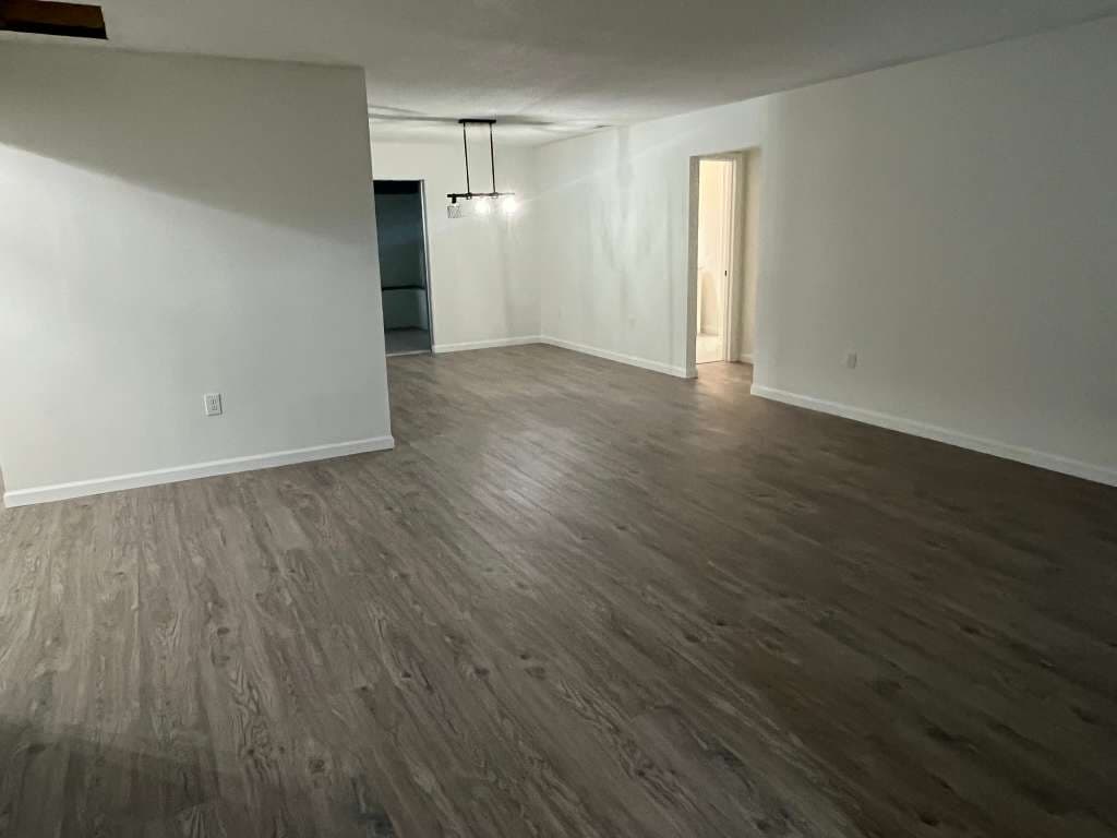 Completed room remodel with hardwood flooring and white walls in North Port FL