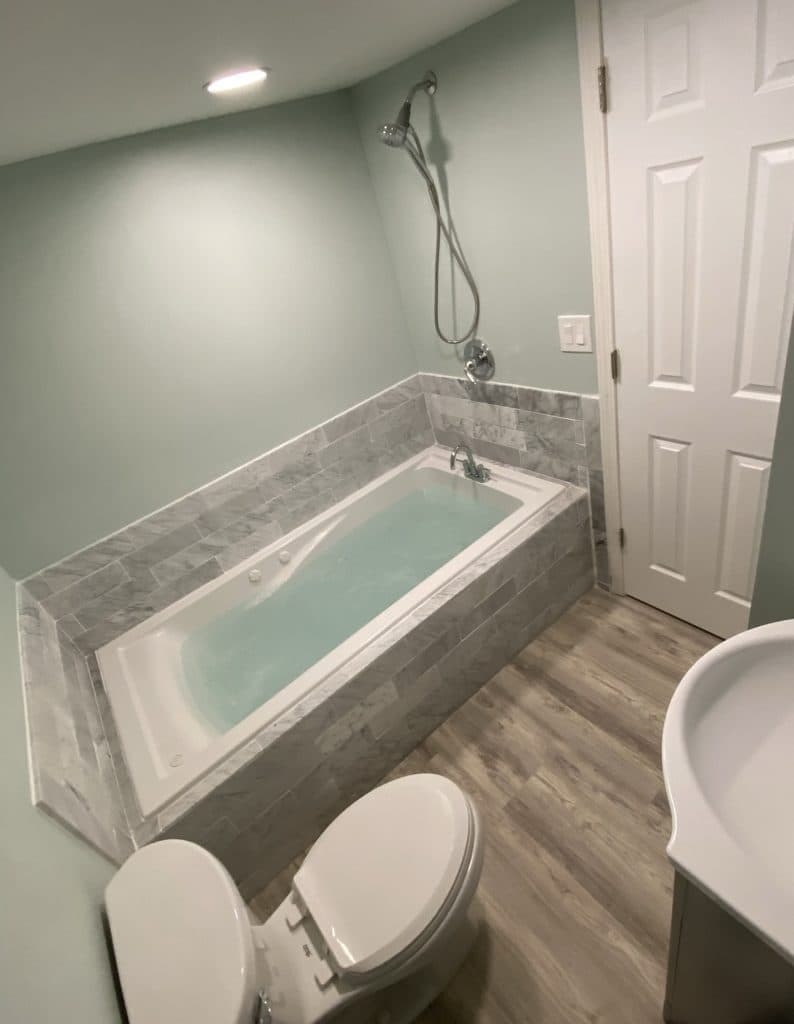 Luxury bathtub installation with marble tile surround in Sarasota County