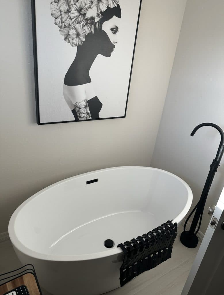Freestanding soaking tub with matte black floor-mounted faucet